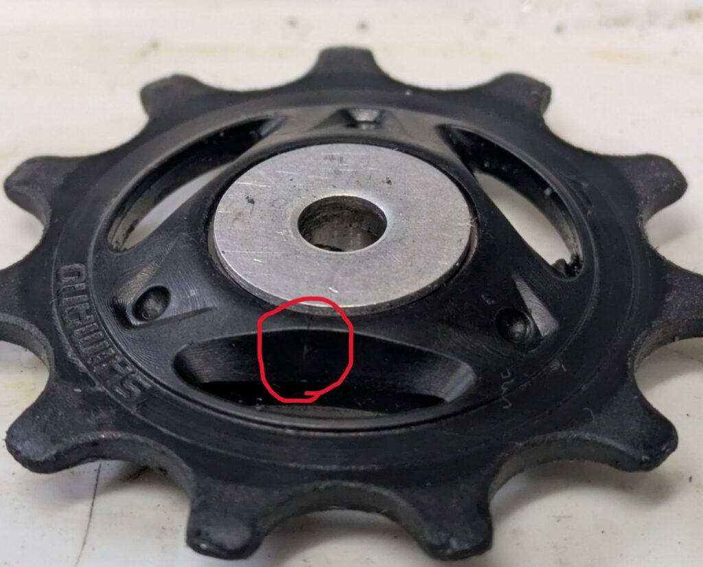 SHIMANO 12速プーリーの樹脂部分に発生した割れを赤丸で示した画像